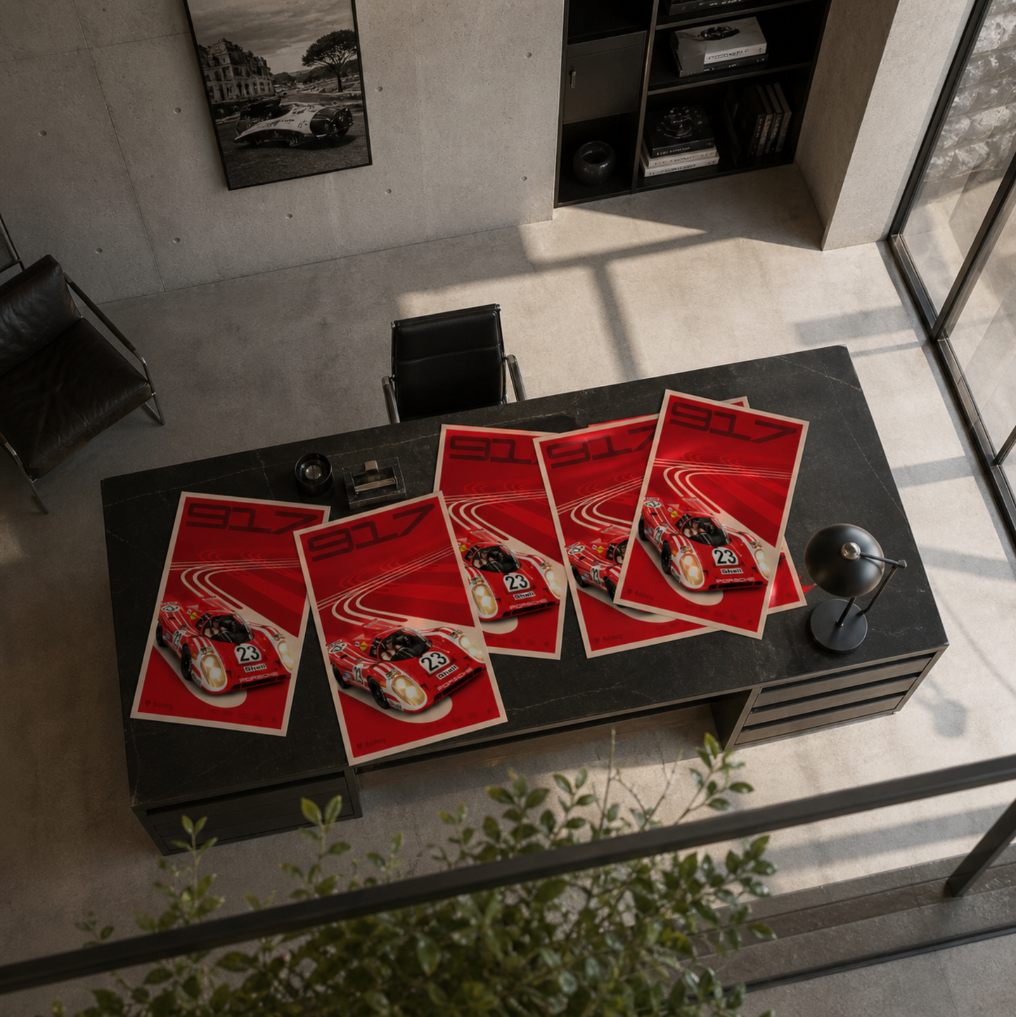 Black office desk with red Porsche 917 posters in a modern office setting